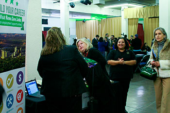 Group of people attending the community engagement fair standing in front or near various booths