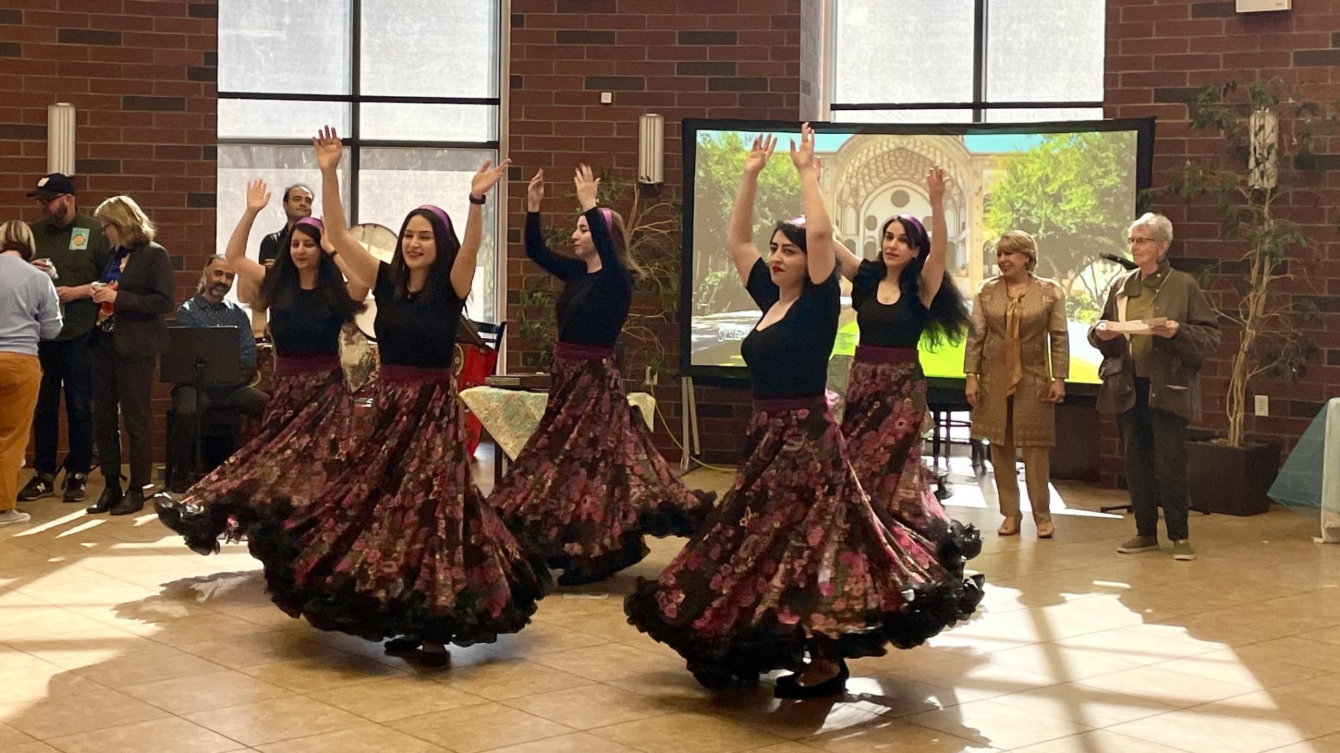 Persian Dancers twirling with arms held upwards